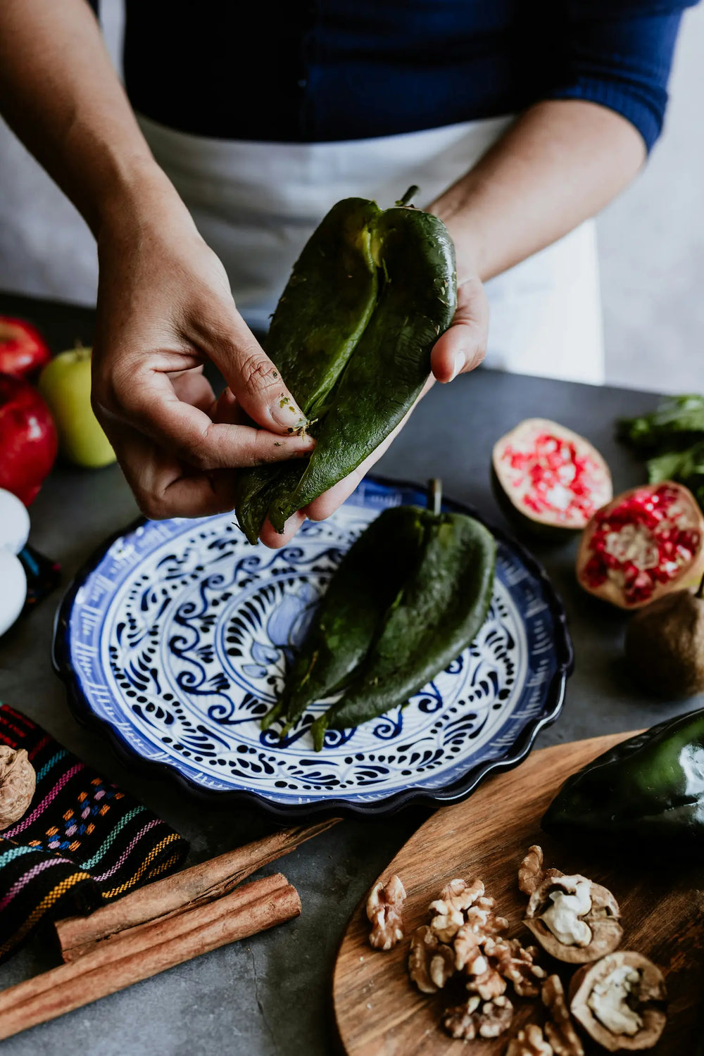 Poblano peppers charring on a grill, skins blistering