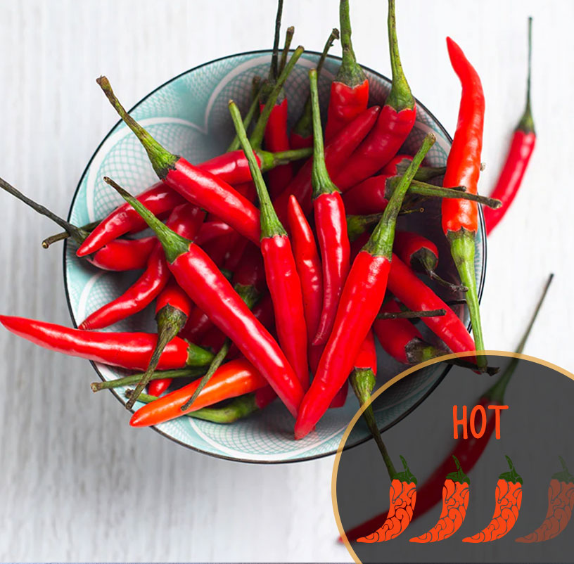 Bowl of red Thai chili peppers with a 'HOT' label inset on a white background